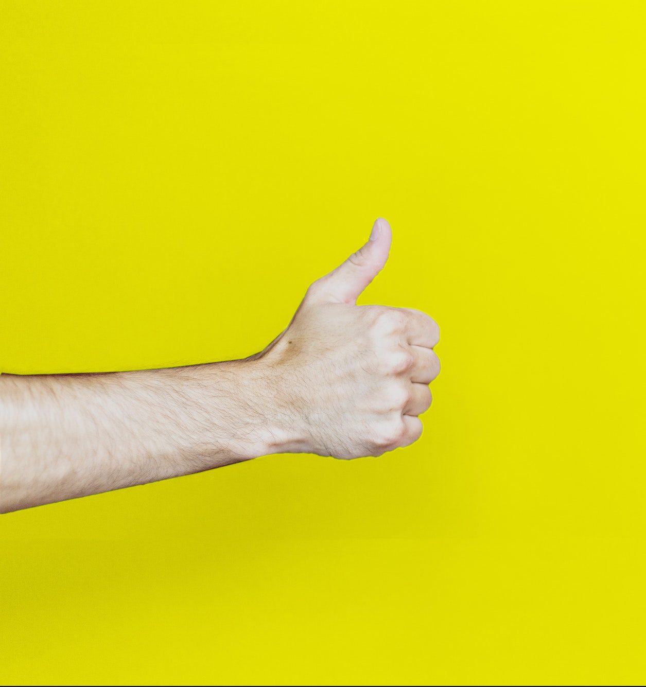 Close-up of hand against yellow background